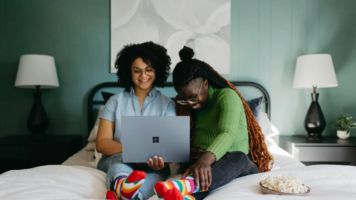 a woman sitting on a bed using a laptop